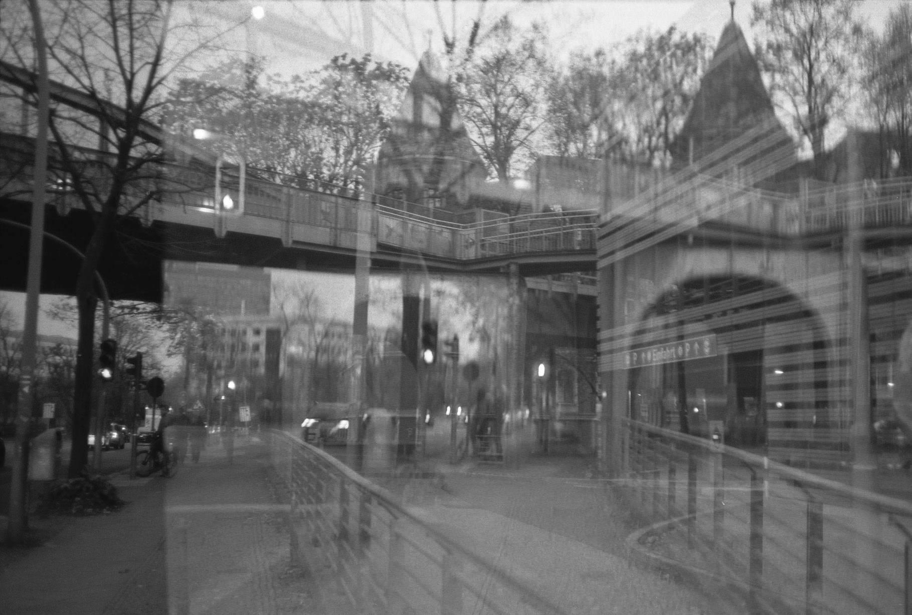 double exposure of the entrance of a subway train station and the bridge for the train tracks