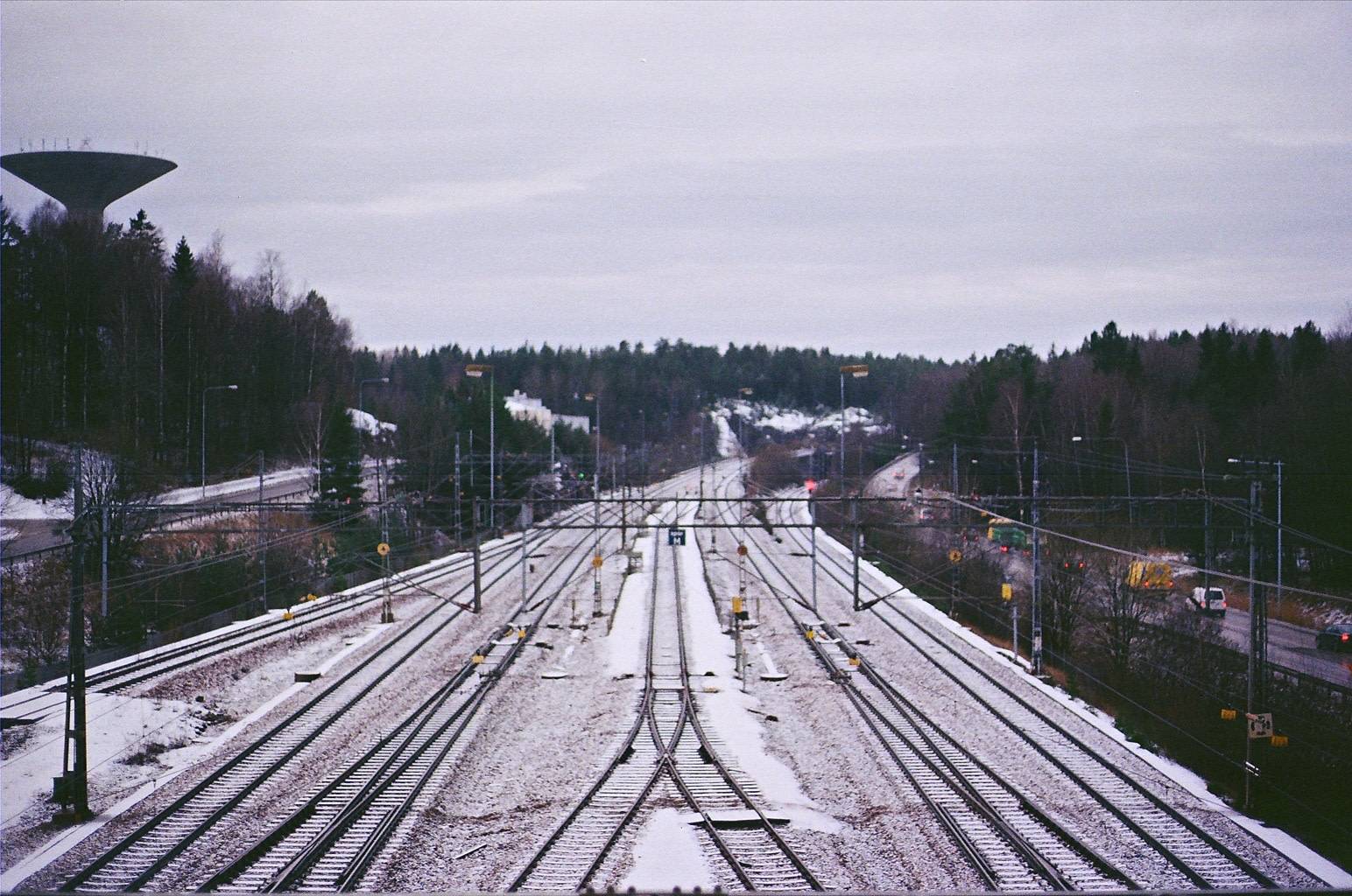 snow covered train tracks seen from above converging into horizon
